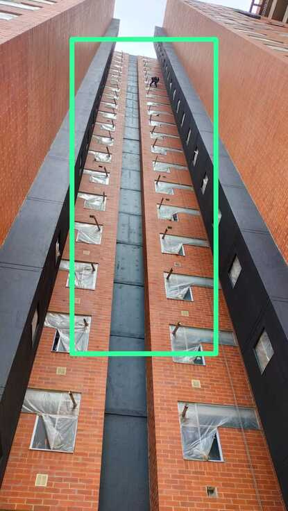 Culata de edificio en ladrillo con protección de ventanas durante la intervención