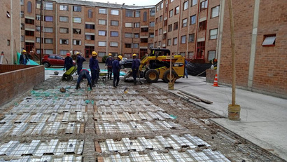 Equipo de obra y minicargador retirando adoquín para cambio de placa